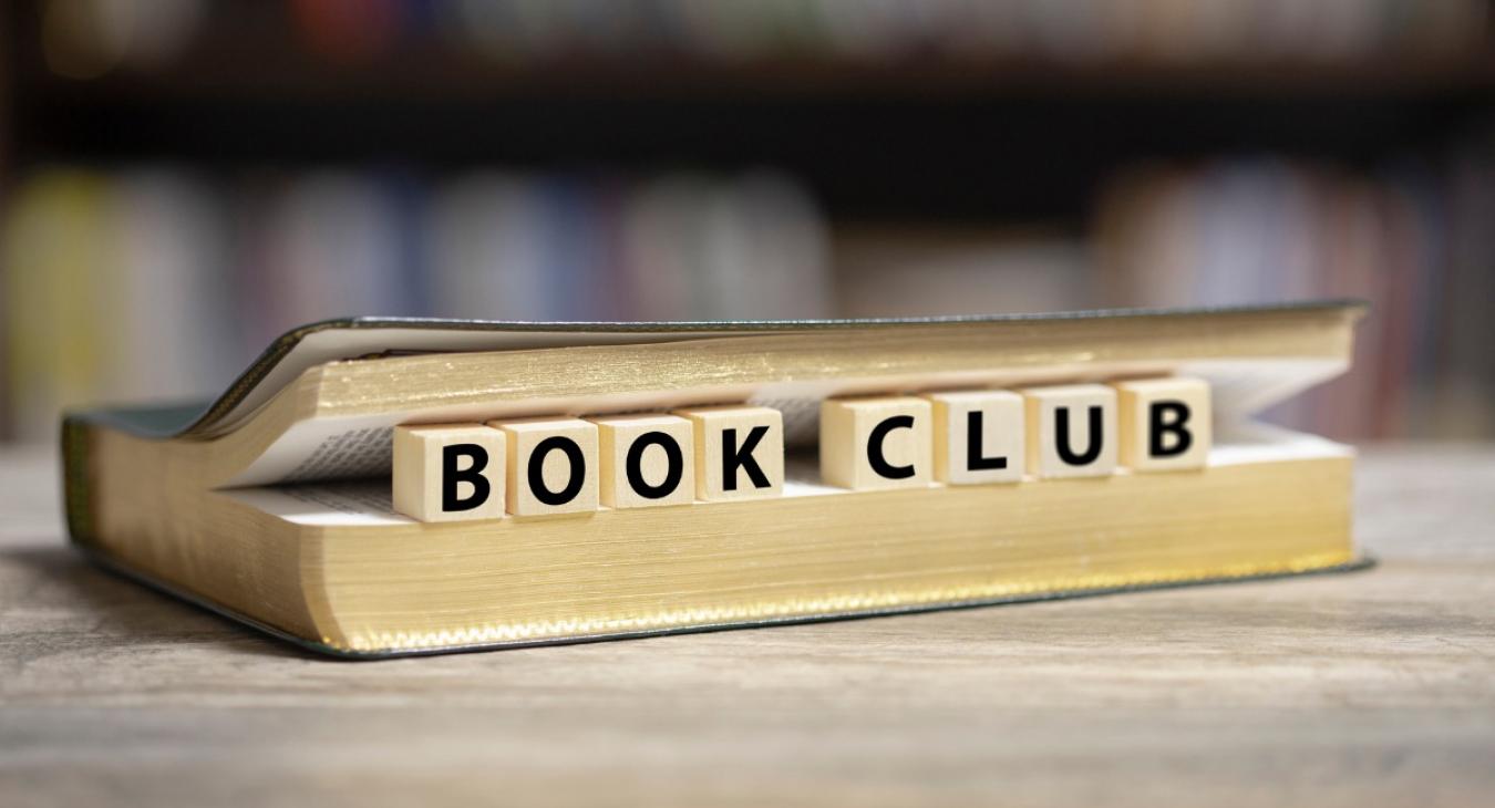 Graphic showing a book with blocks spelling the words "Book Club"